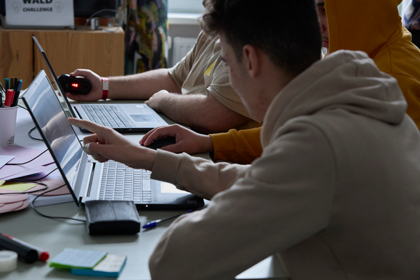 Jugendliche tüfteln gemeinsam an einem Laptop