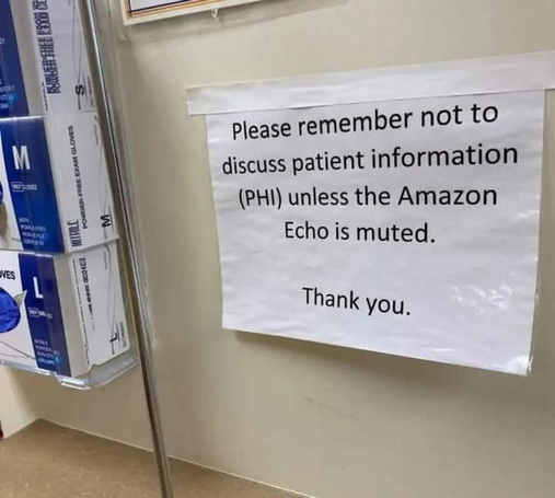 A sign on a door of a healthcare facility that says: "Please remember to not discuss patient information (PHI) unless the Amazon Echo is muted."