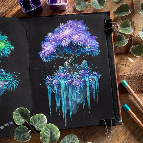 A photo of an open black paper sketchbook placed on a wooden table and surrounded by small paint tubs, coloured pencils, and leaves for decoration. The open page features a tree with lavender foliage on a seemingly floating chunk of rock, turquoise water spilling over its edges. At the base of the tree purple foliage is growing, and a few small rocks point upwards. Little glowing lights surround them.