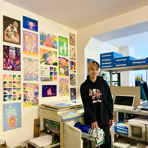 Molly devant un mur de posters en riso colorés