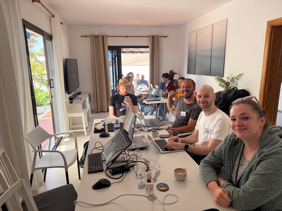 People hacking on their laptops inside the living room of a villa