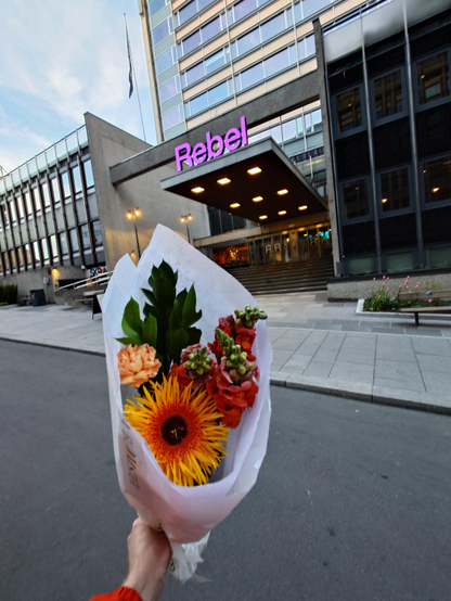 A photo of a bouquet of a brightly coloured selection of flowers outside Rebel Oslo - the conference hall.