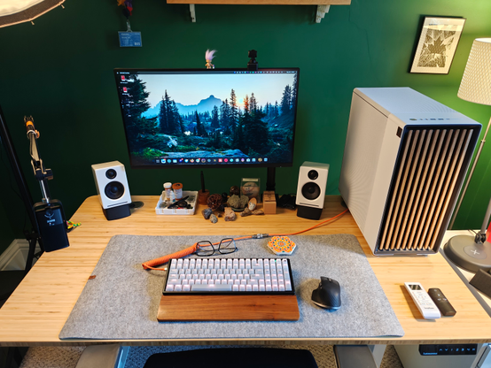 A computer setup on a desk. Minimal aesthetic - clean, white and wood accents