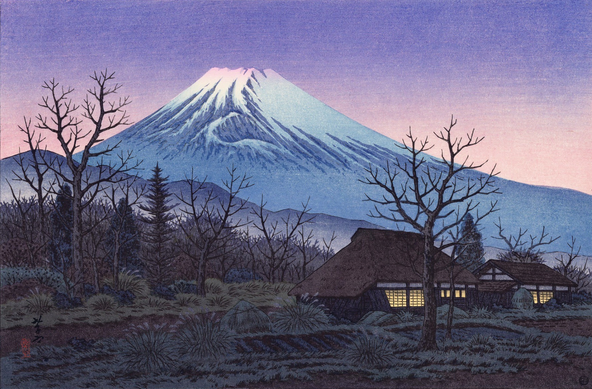 Sunset, looking toward Mount Fuji from a farm in Susono, Shizuoka. In the foreground, trees are bare, waiting for spring. A pair of farmhouses, one with a traditional thatched roof, have been closed up for the evening; warm light glows in their windows. Nearby, rectangular vegetable patches have been sown in tidy rows, but have yet to develop much. Beyond, forests and foothills lead toward a snow-capped Mount Fuji, still shining in a sky turned purple and pink with the setting sun.