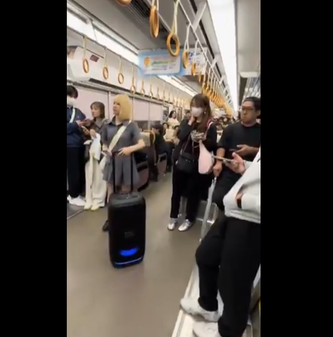 Senpu with a large JBL suitcase-style speaker on a train