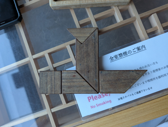 Wooden puzzle arranged in a shape resembling a steam boat.
