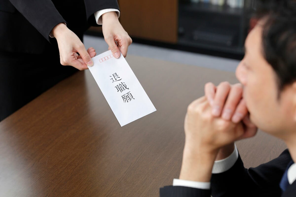 A woman handing her boss a letter of resignation