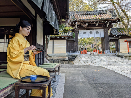 Nao-san enjoys aburi-mochi beside Imamiya-jinja.