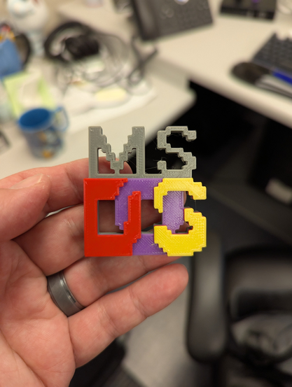 Holding a 3d print of the MS DOS logo. 