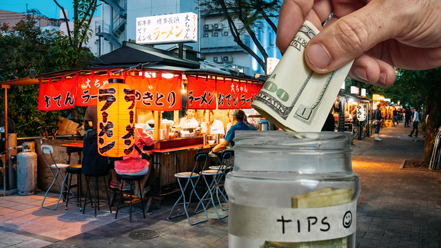 Picture of an open air ramen shop; in the foreground, a hand deposits USD into a jar