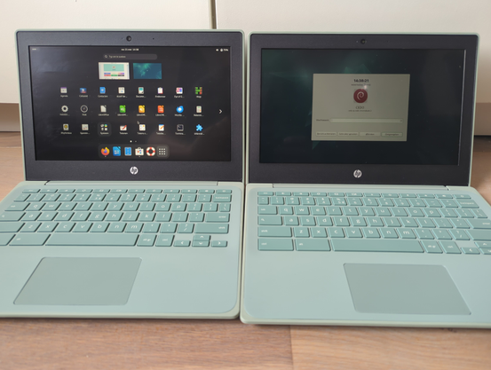 Twee mint groene Chromebooks, met daarop DebianEDU. De linker met het Gnome HUD scherm, de rechter met DebianMATE inlogscherm. 