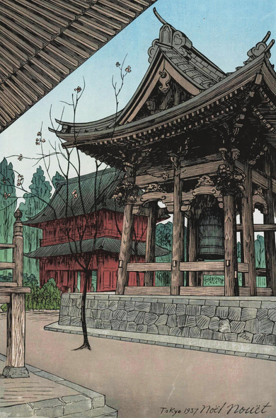 A view looking up at the temple bell at Ikegami Honmonji on a bright spring day. A single tree stands between us and the bell, a few pink blossoms clinging to its otherwise bare branches. The tall temple gate stands beyond, flanked by green trees; above, the sky is blue and cloudless.