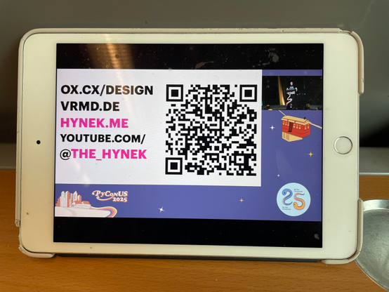 iPad mini showing hynek‘s PyConUS talk with a qrcode for slides and a lot of links.