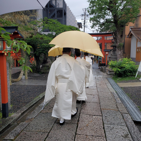 The priests of Yasui Konpiragu depart under matching umbrellas.