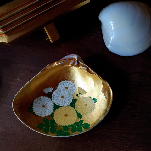 Chrysanthemums painted on the gilded interior of a shell.