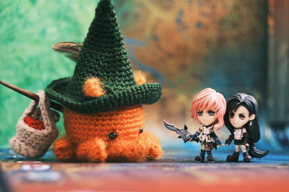 A photo a crocheted Octopuff traveler (from the Octopath traveler series), and figurines of Lighting (from Final fantasy XIII) and Tifa (from Final fantasy VII) placed facing each other as if they were engaged in a JRPG battle.
