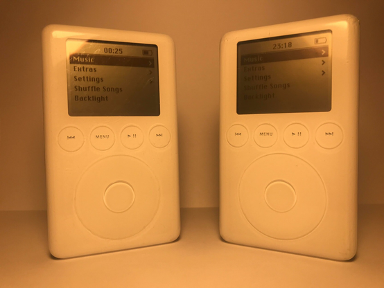 Two iPod Classic 3rd Gens, standing upright, showing home screen