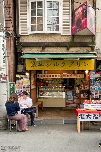 Customers enjoying "Asakusa Silk Pudding" outside a small store in the Asakusa area of Tokyo, Japan.