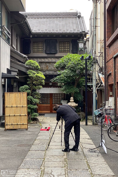 A photographer setting up a shot of an old building in the Asakusa area of Tokyo, Japan.