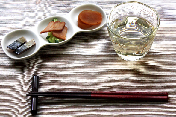 A serving of three otōshi along with sake and a set of chopsticks