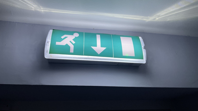 An illuminated emergency exit sign above a door in a dark hallway. I know it’s nothing to do with the post, but I enjoyed the way the light shines softly on the wall but sharply on the ceiling.