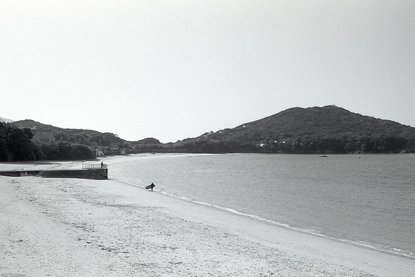 A surfer on a beach. No waves.