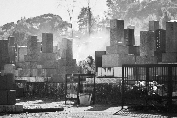 A woman praying in a Japanese cemetery.