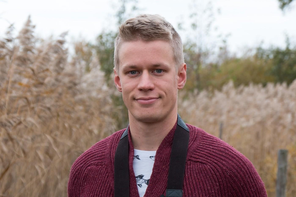 Patrik Lauha standing in front of tall reeds.
