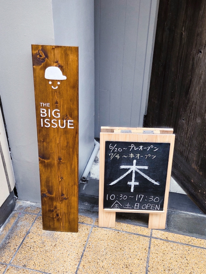 ビッグイシューのシェア本屋「希望をつむぐ本屋さん」の立て看板が二つ写っている写真。

【看板の情報】
"THE BIG ISSUE"
6/20～　プレオープン
7/4～　本オープン
営業時間 10:30-17:30（金・土・日 OPEN）