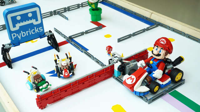 It's a 2x1m table with two remote controlled Mario Karts built with LEGO parts. Colors on the table make the karts spin or get speed boosts. A moving wall obstructs the course randomly.