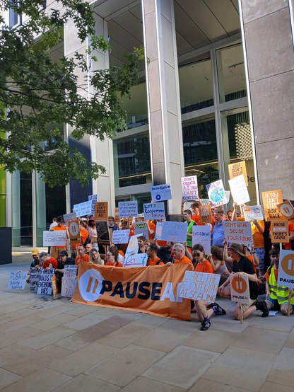 Photo of a group of protesters for a demonstration led by Pause AI holding a banner and placards.