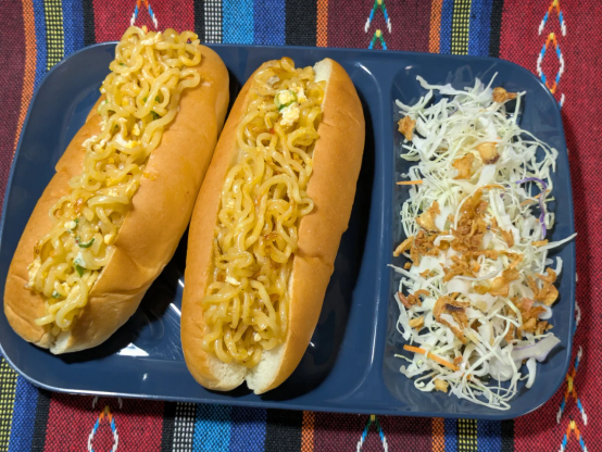 コッペパンに辛ラーメンを挟んだ「辛ラーメンパン」。隣は付け合わせサラダ。