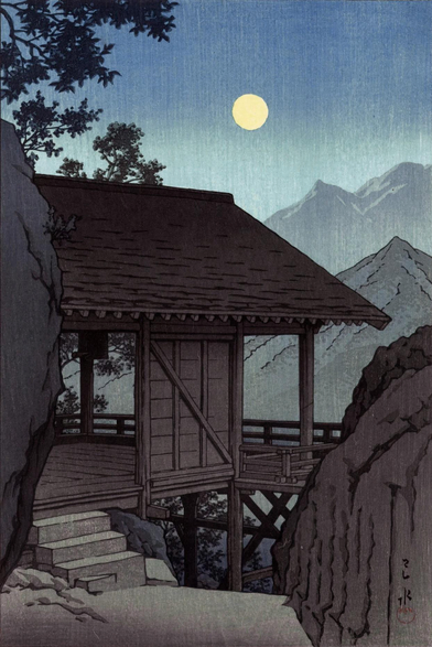 A full moon rises over a corner of Yama-dera, or Risshaku-ji, high in the mountains of Yamagata Prefecture, Japan. The surrounding terrain is steep and dramatic; above, the sky is starless, and occupied solely by the pale yellow moon.
