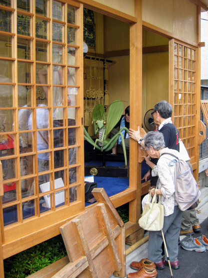 Visitors watch a model of the float's praying mantis being put together.