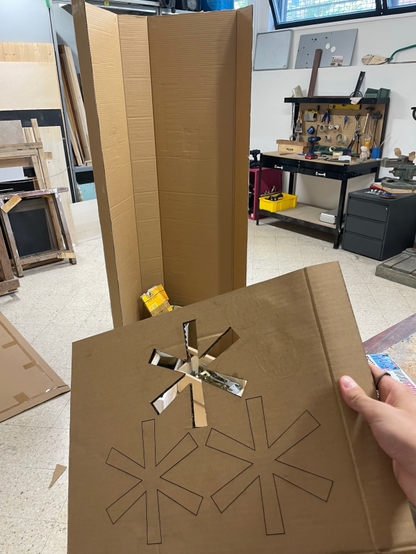 The Fediverse symbol engraved in a cardboard stencil, and a human-size cardboard construction on the background.