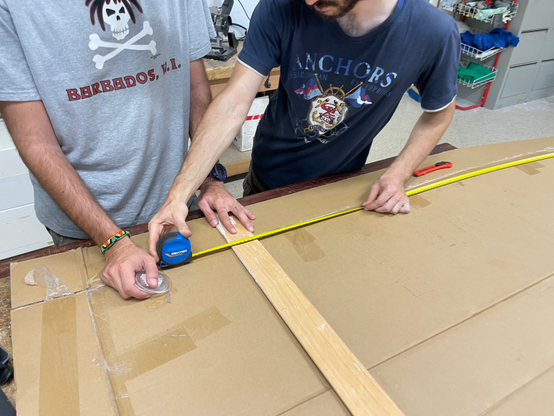 Maurizio and Pietro measuring the cardboard in order to cut it so that it matches my height.