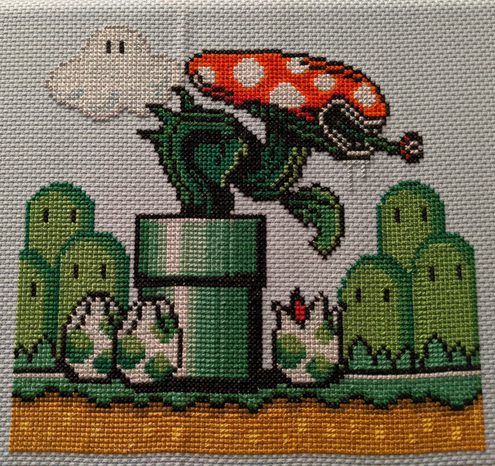 A cross stitched image of a piranha plant from Mario with the head of a xenomorph from Alien. The plant is coming out of a pipe and at the base of the pipe are yoshi eggs with split tops like a facehugger egg. 