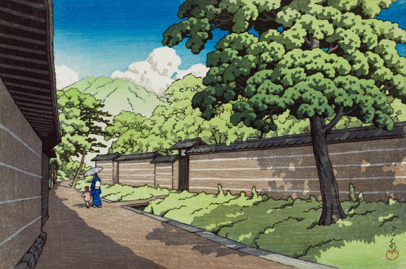 A view looking down a straight, tidy little lane somewhere in Nara, on a bright summer day. The lane runs between walled properties. On our right, a tall tree grows in a strip of greenery on our side of the wall, and more trees stand on the other side. Further along the lane, a female figure in a blue kimono walks alongside a child in a striped dress; the woman holds an umbrella over her head as protection from the sun. In the distance beyond, a forested mountain topped with puffy white clouds rises into an intense blue sky.