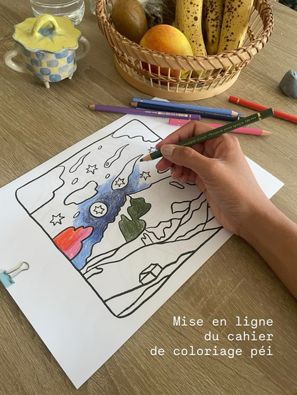 Photo d’une main qui colorie un coloriage au crayon de couleurs.