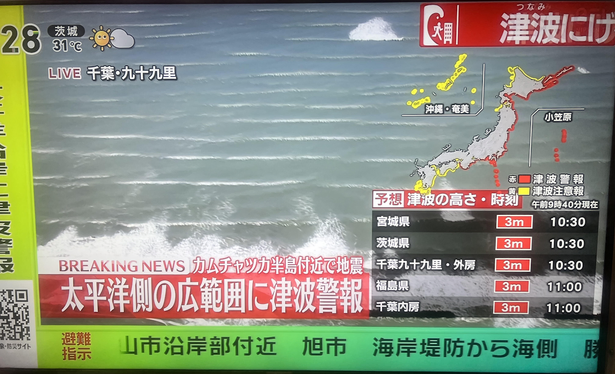 Alerts on Japanese TV as of 10:29am. The red text in the upper right corner says "Flee the Tsunami!" and is printing "EVACUATE!" in English