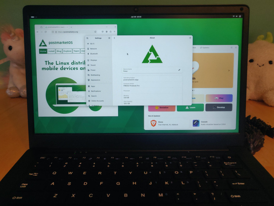 Photo of a pinebook pro running the GNOME desktop environment, booted on an experimental immutable install of postmarketOS. Firefox is running on the left, with postmarketos.org open. In the middle is the GNOME Settings About app, and on the right is GNOME software ready to install flatpaks.