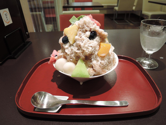 Kakigori covered with slices of fruit and balls of mochi.