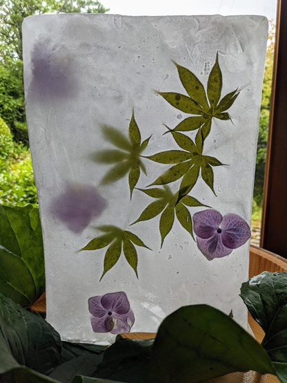 A block of ice containing decorative flowers and leaves, helping guests cool down.