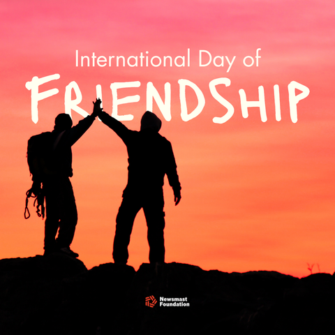An image showing the silhouette of two mountain climbers against a pink/orange sunset high fiving. The text reads: International Day of Friendship. Newsmast Foundation.