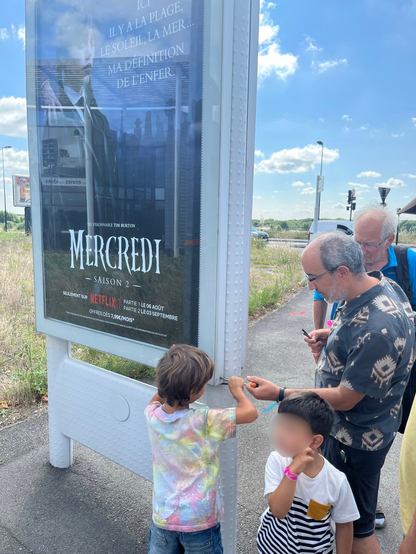 Photo une action sur un panneau de pub. un enfant et jn adulte sont en train de l'ouvrir.