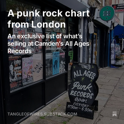 Punk rock record shop All Ages Records seen from the pavement, its window crowded with posters and flyers