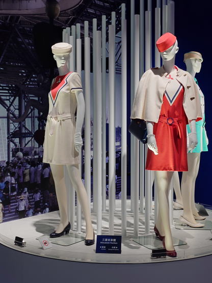 Costumes from the Mitsubishi pavilion from 1970s Osaka Expo, Spring/Summer and Fall/Winter variants. Dresses with red and white designs with some blue accents. 
