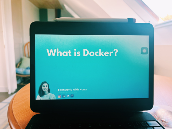 The photo of an iPad (with an Apple Pencil resting on top) with the screen showing a still from a video tutorial from the channel Techworld with Nana about « What is Docker ? »