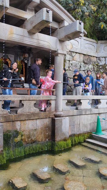 Visitors collect water from one of the Otowa-no-taki's 3 streams to drink in the hope that their wishes will come true.