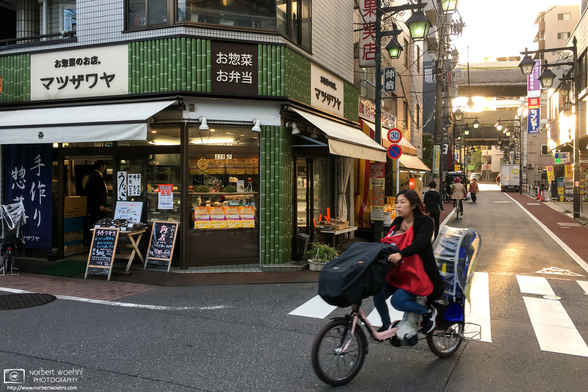 A woman on a "mamachari" (Japanese utility bicycle) is turning a corner in the Nakajuku area of Itabashi Ward in Tokyo, Japan.